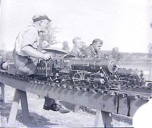 Norman Steele running his 3-1/2 inch gauge 4-4-2 #1101 at NELS Danvers, MA, October 1939. Lester Friend at the throttle of the locomotive in the background.
