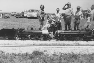John Enders driving the Golden Spike on the Austin & Texas Central Railroad at Manor, Texas, 1974. Paul King kneels beside him. Also in the photo are Carolyn Enders Balkum, Ces Beck, Everett Adcock, Louise Adcock, Cliff Pettis, unknown, and Lee Balkum. Photo from Stephen Balkum collection.
