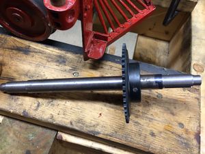 A completed axle with the #25 chain drive sprocket attached with a tapered pin. The pin has been lightly driven in with a chisel and hammer, and the extra length cut off neatly.