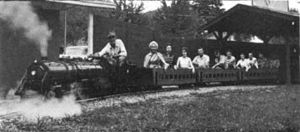A picture of Daniel Boone's train that he built himself. He lives at Burnsville, N.C. The weight of the locomotive and tender is 2,916 lbs., overall length, 14', 8'. All ball and roller bearings. Daniel Boone at the throttle.