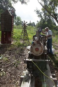 John Greiner checks out the tank of a scaled railroad and train along his property just east of Rogers.