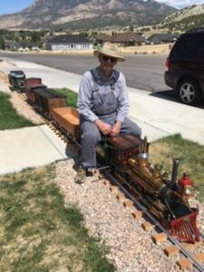 Harry Heil at the throttle of his first live steam locomotive riding the rails of his home track in Nephi, Utah.