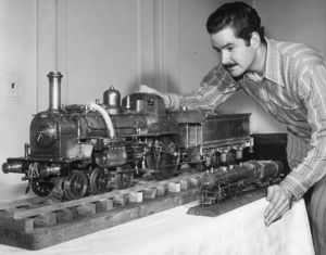 Ken Shattock with his one-inch scale 6-2-0 British 'CRAMPTON' in Oakland, CA., 1973. CRAMPTON was the 19th locomotive constructed by Victor Shattock and was completed in 1969. The Prototype is circa 1845. The smaller brass loco sitting next to the CRAMPTON is a 1/4-inch scale, O-gauge model of a Southern Pacific GS-1 4-8-4 that was built by EBMES co-Founder and GGLS member Walter I. Brown. It too was Live Steam and burned denatured alcohol for fuel.