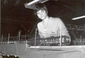 Suzie Shattock, Ken Shattock's wife, inspecting a long line of O gauge trolley cars, circa 1975.