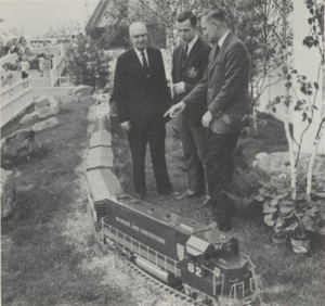 BAR President W. Jerome Strout, Marshall Rice, Jr., a state employee, and Vice President-Operations and Maintenance Palmer H. Swales look over an operating model of a Bangor and Aroostook train at the Maine Pavilion at Expo67.