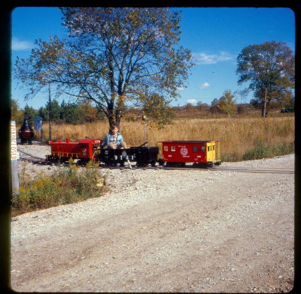 File:John D Atkinson engineer crossing M-11 on Atkinson Railroad 10 Oct 1967.jpg
