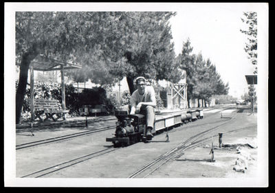 Kenneth "Skid" Roeh at the throttle of a narrow gauge 2-62- running on the 4.75 inch track, Los Angeles Live Steamers, north side of the facility looking east toward Glendale, CA. Over the ivy covered chain link fence is Zoo Drive. See Chaski.org