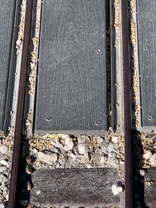 Closeup of grade crossing showing detail of aluminum rail on side as spacer/guard rail.