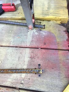 The welding jig can be very simple. Lay out the rebar on a flat wooden surface, then drive sheetrock screws into the wood as shown.
