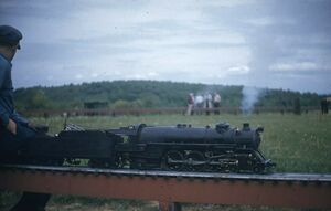 Unknown locomotive and engineer on three-quarter inch scale high-line. Could this be Charlotte, NC? From eBay.com, August 2020. Seller states this slide was from the 1950s.