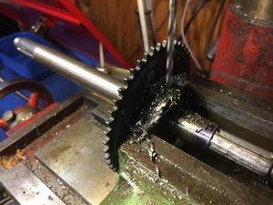 Drilling a hole through the sprocket and axle. The hole will be tapered with a reamer. Be sure to use lots of lubricant to keep the bit cool. Make sure the hub of the sprocket is facing towards the short end of the axle.