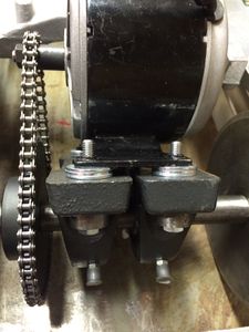 Washers may be inserted between the motor and block bearing to remove slack in the chain.
