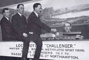 Henry Greenly on the back of the "Challenger" spirit-fired locomotive, 1924 Model Engineer Exhibition, Royal Horticultural Hall. Greenly and LBSC had been challenged to compare examples of the two types, in public. W.J. Bassett-Lowke, with only his head visible on the right of the photo, appears to be enjoying the proceedings more than Greenly.